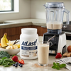AtLast! Vanilla Milkshake meal replacement protein powder on kitchen counter with blended shake, banana, strawberries, and fresh greens